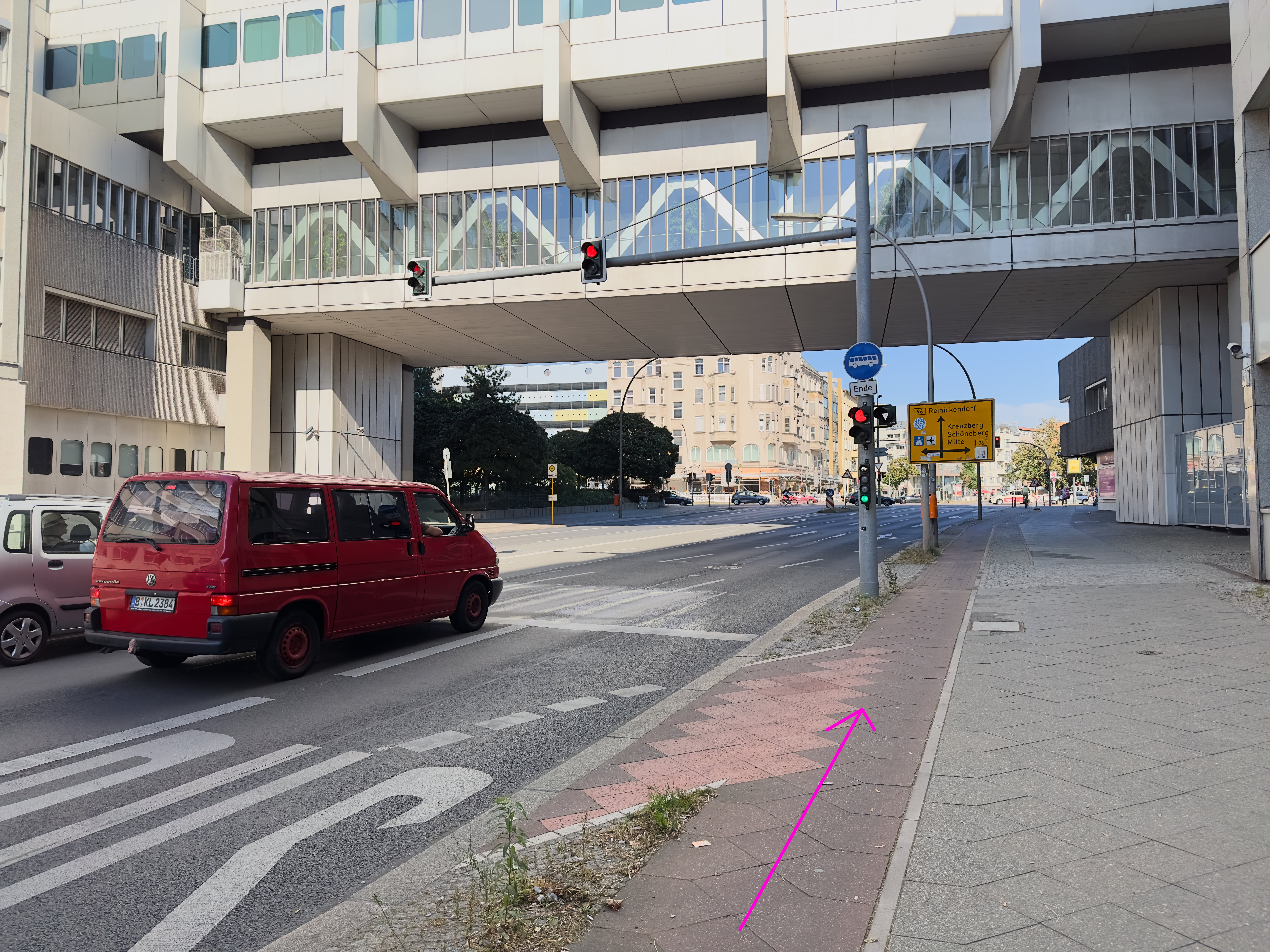 A two-lane road with right-hand traffic. There is a traffic light, but no intersection ahead. A bike lane runs to the right of the traffic light. The traffic light pole has a traffic light specifically for bikes. The bike path does not have a white line indicating where to stop.